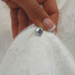 A wedding dress with the dress up - a train pin - with a glamorous stone. 